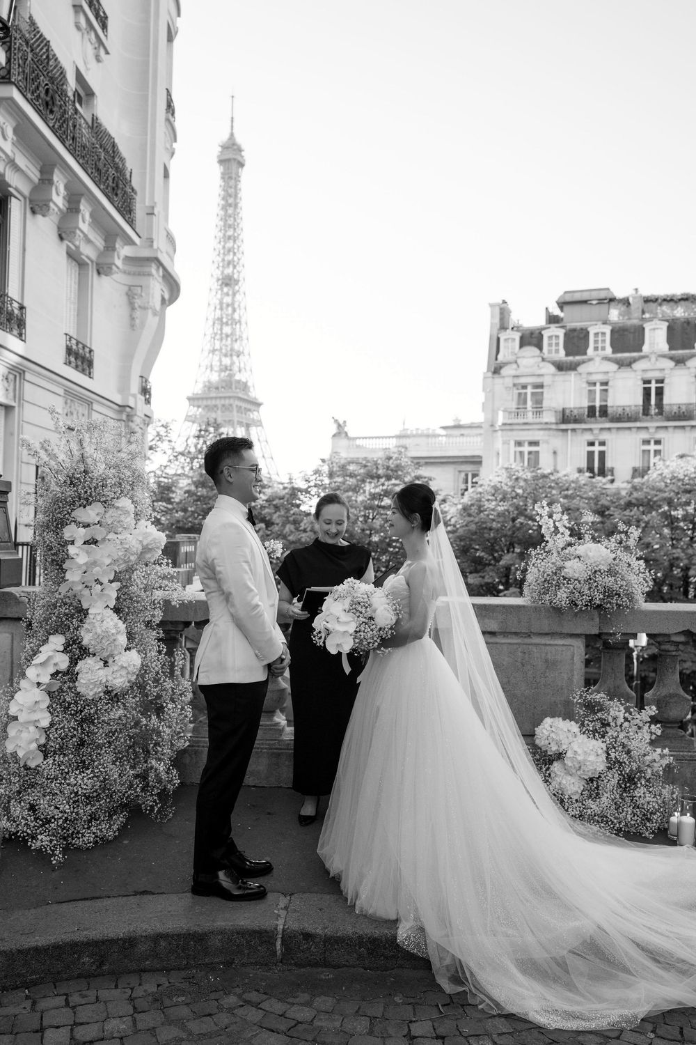 A wedding ceremony on a Parisian balcony with the Eiffel Tower visible in the background.