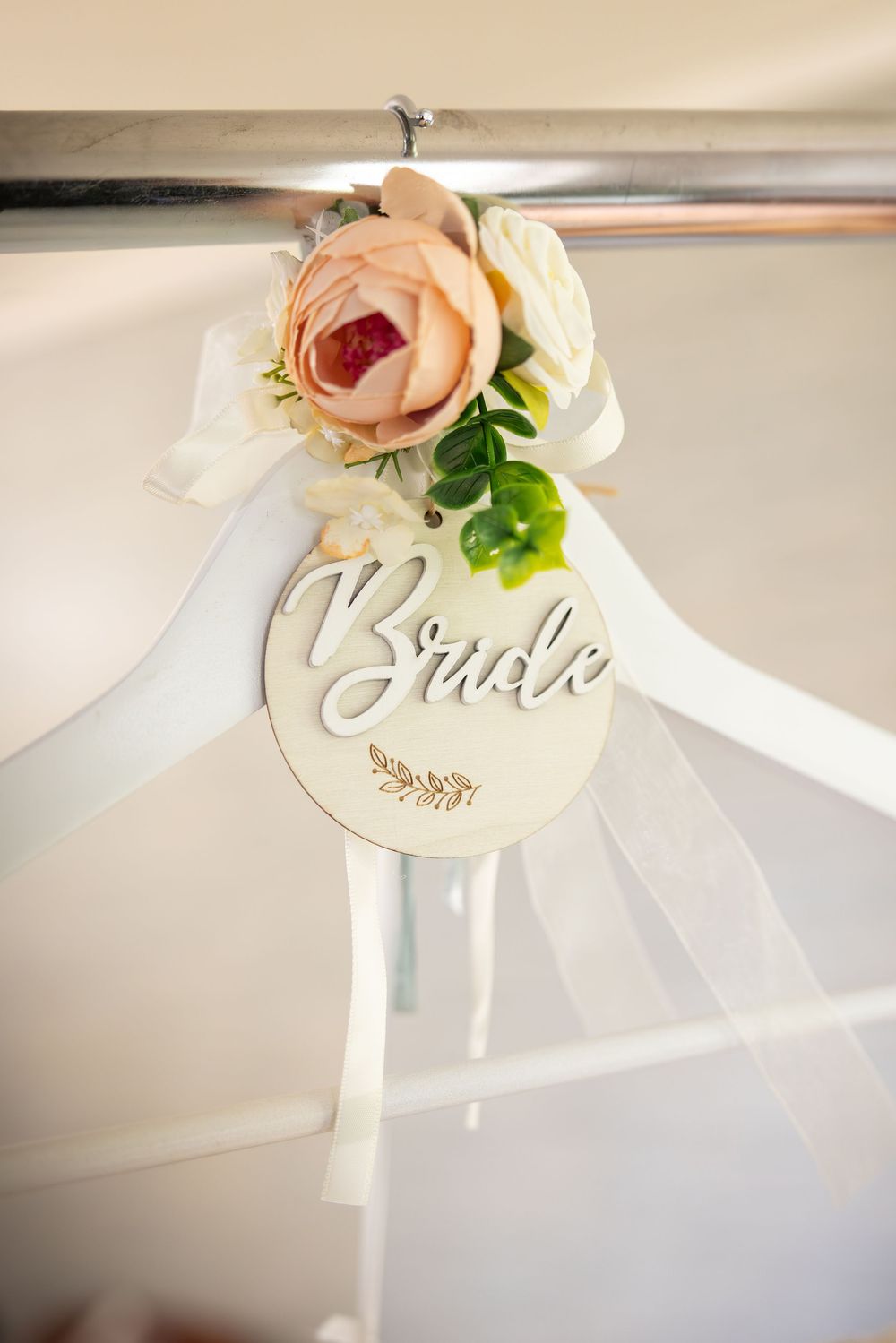 Elegant wedding place cards with calligraphy and delicate peach roses on a white surface.