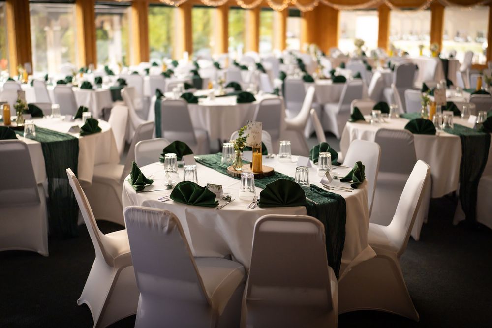 Elegant wedding reception venue with white chair covers and warm lighting creating an intimate atmosphere.