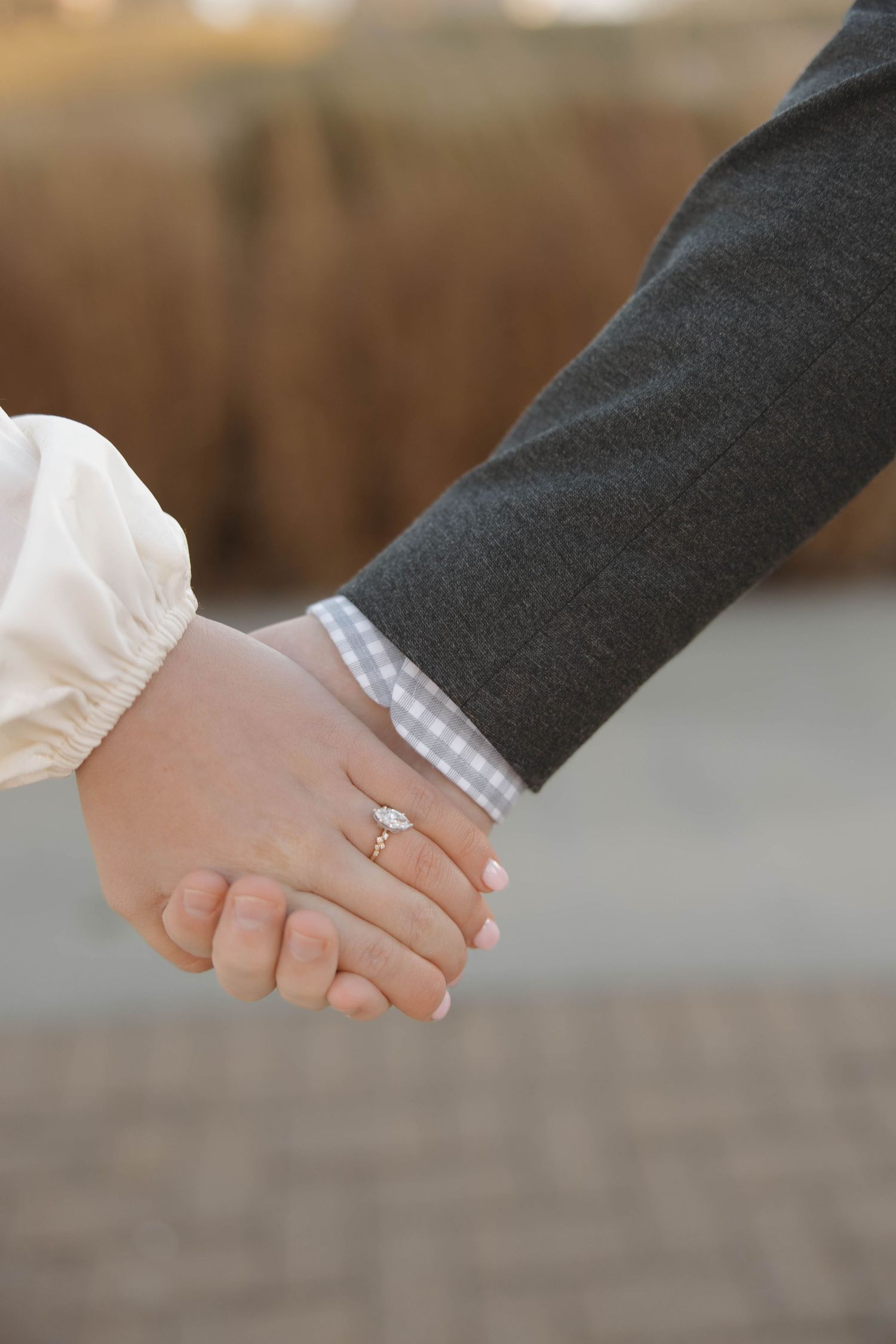 Close-up shots of hands clasped together showing engagement rings and tender moments.