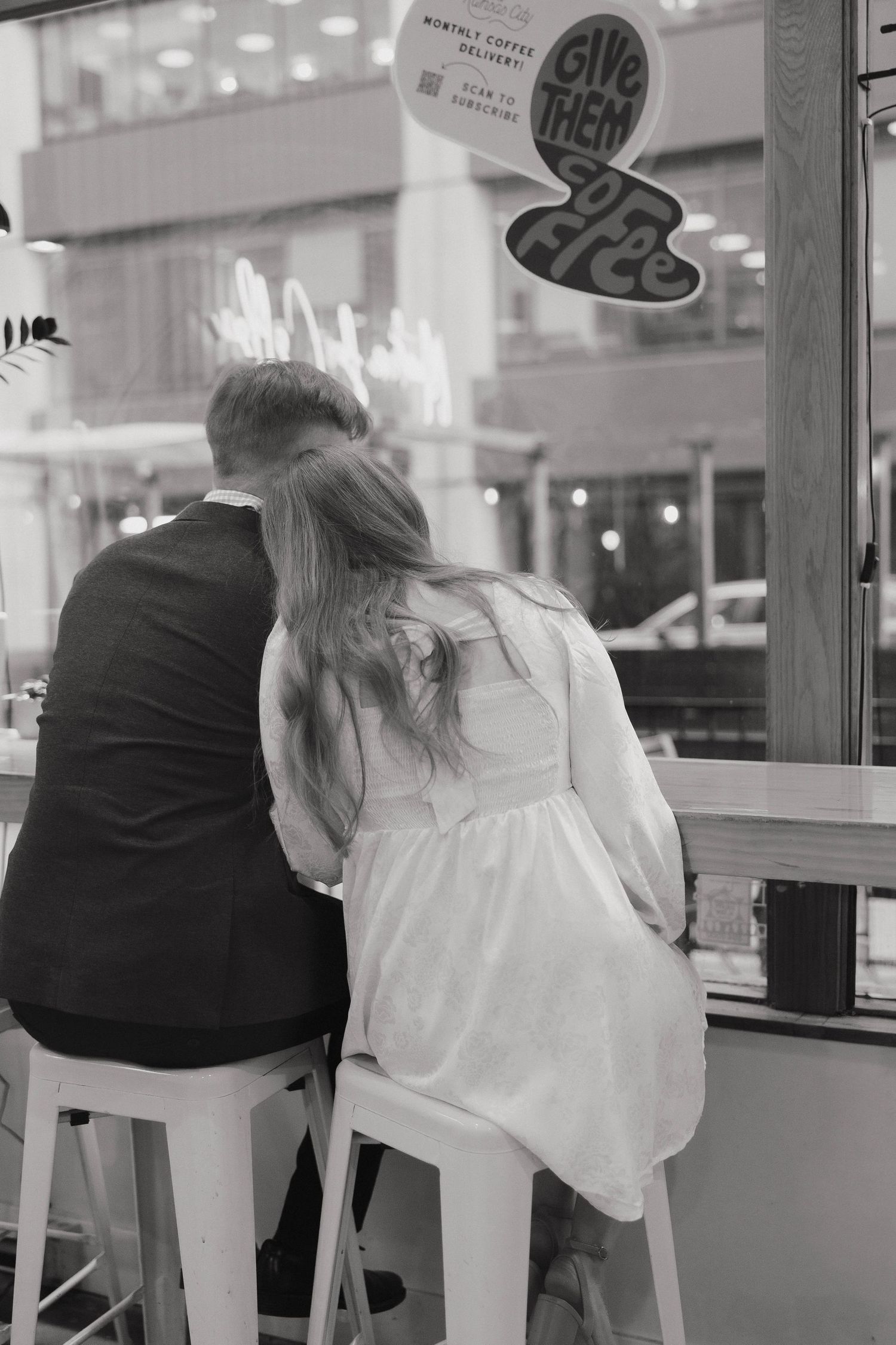 A couple sits at a retro-style diner counter with vintage lighting and decor visible in the background.