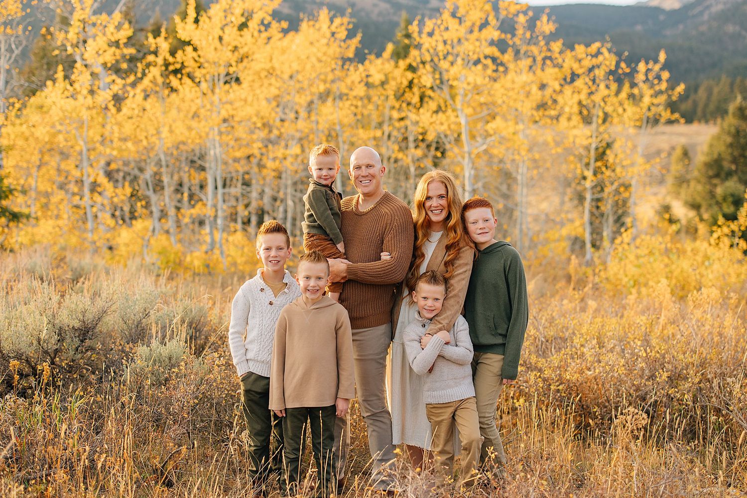 Group photo with mountain vista and vibrant yellow aspen trees in autumn setting.