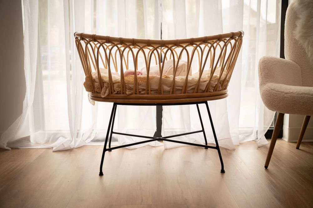 lifestyle newborn photography session in Fort Worth Texas of newborn baby girl in a boho bassinet asleep