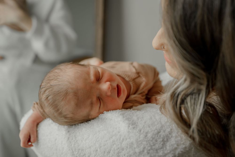In home lifestyle newborn session in DFW mom holding baby