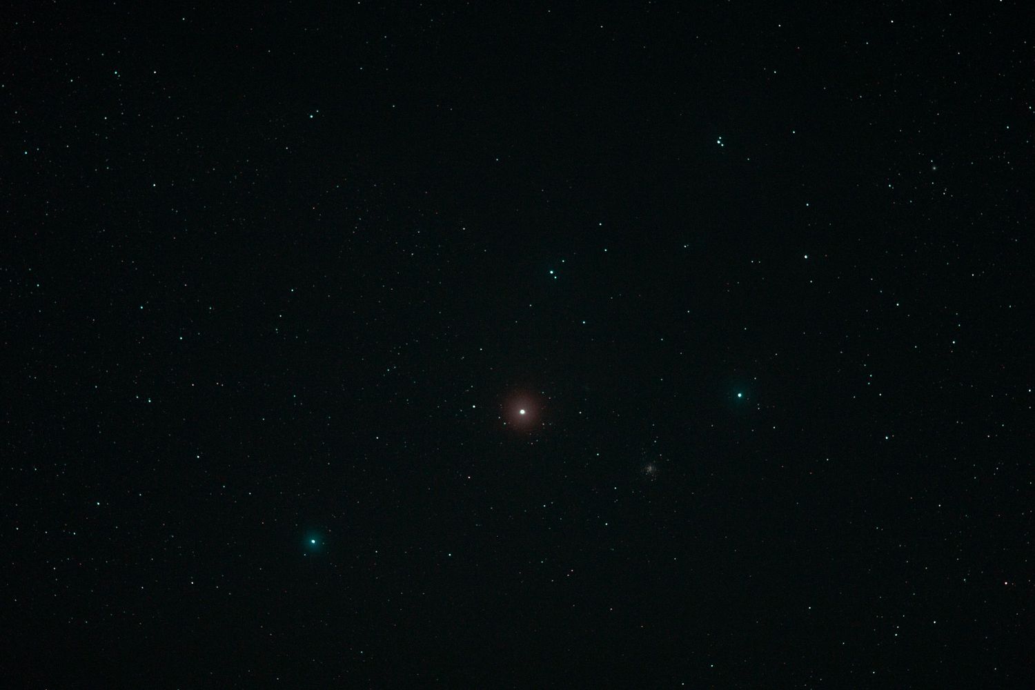 A starry night sky with a bright red star or celestial object visible against the dark background, this is Antares within Scorpio