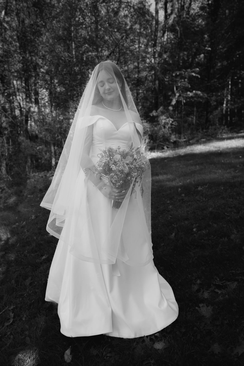 A series of black and white photos showing a bride in a flowing white wedding dress and veil in an outdoor wooded setting.