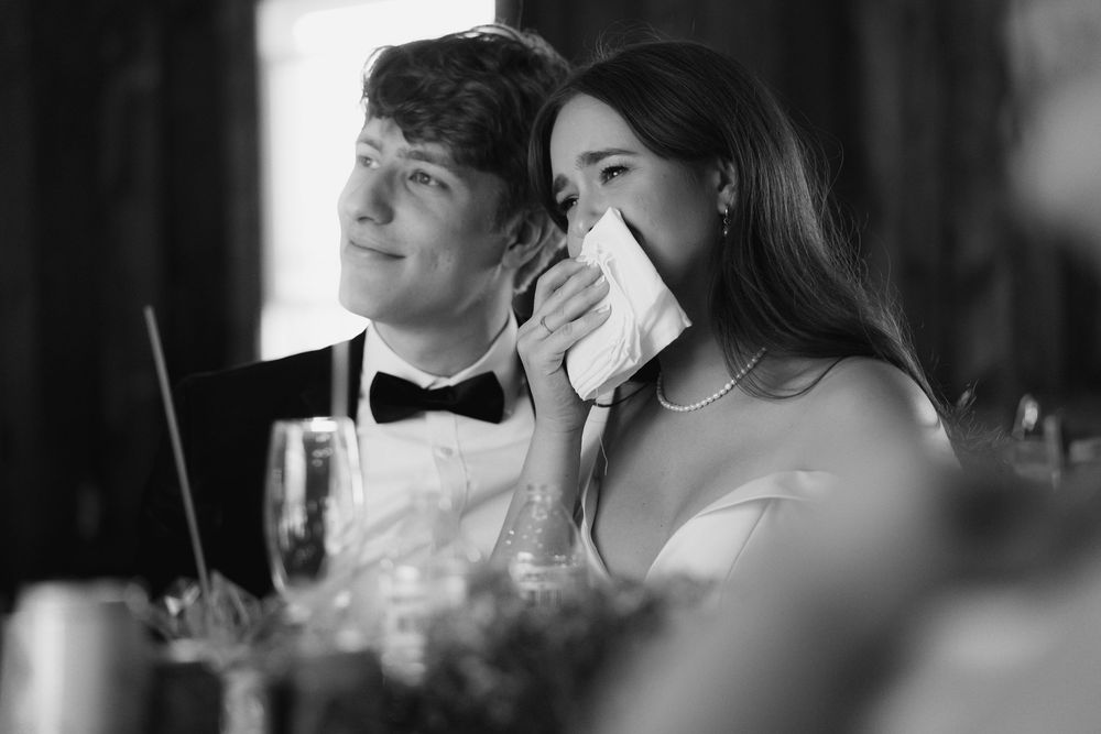 Black and white photo of a couple on their wedding day sharing an intimate moment during the reception.