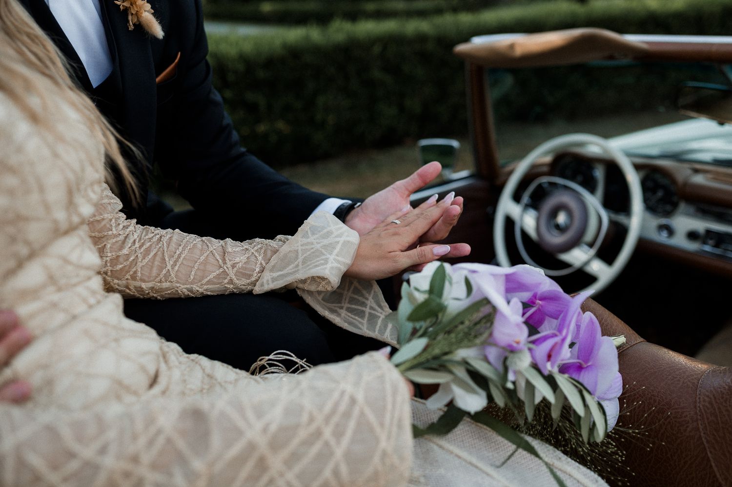 Intimate wedding portrait of newlyweds embracing on manicured lawn during golden hour.