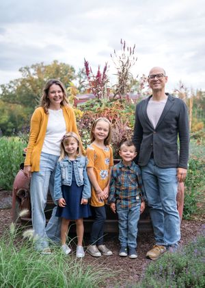 A group in coordinated casual outfits with denim and yellow accents poses together outdoors in autumn scenery.