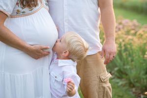 A series of maternity photos showing a pregnant woman in a white dress holding her belly in an outdoor setting at sunset.