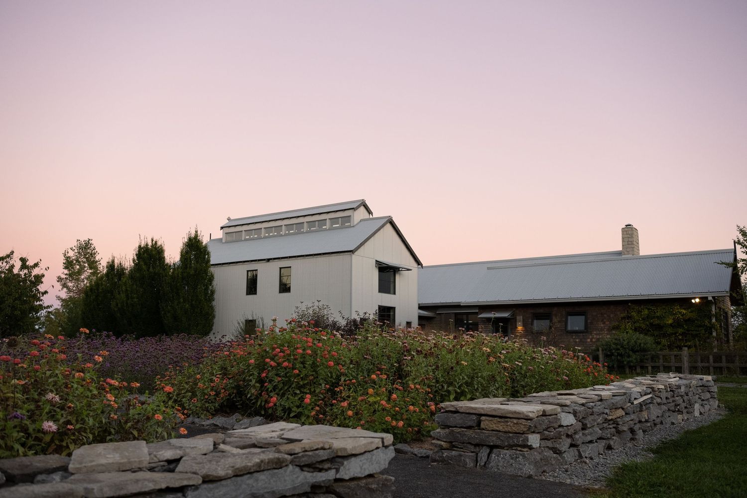 Stone buildings and barns at dusk with dramatic purple sky.