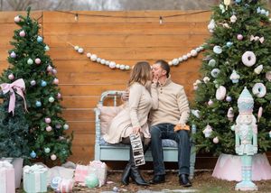 Festive holiday scene with decorated Christmas trees and a rustic wooden bench with garland.