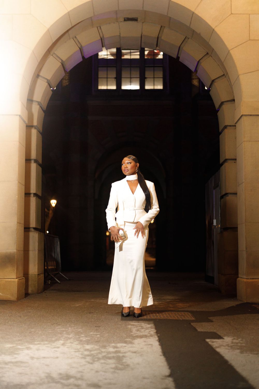 A sequence of five photos showing a figure in white clothing moving through a stone archway corridor.