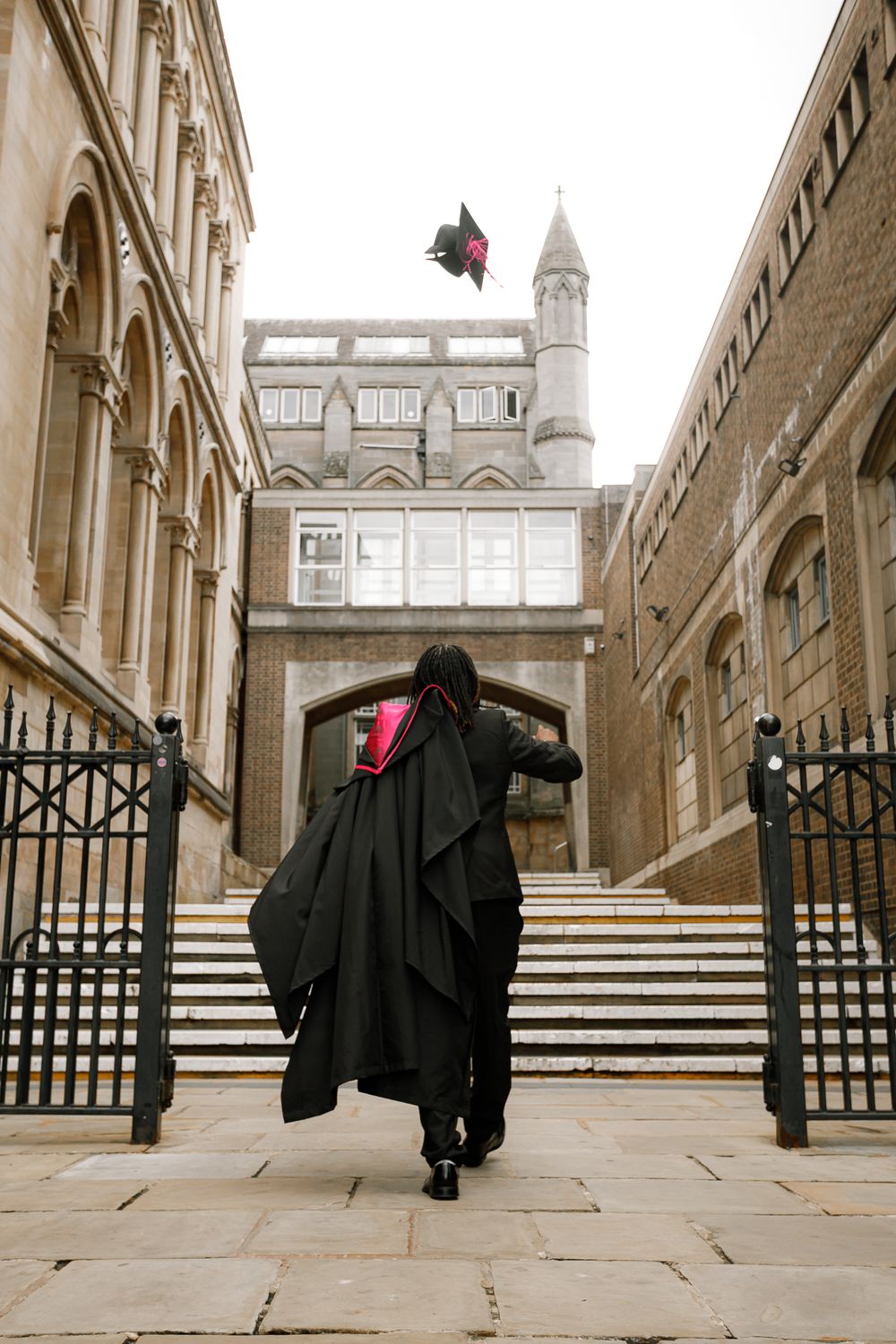 A series of four sepia-toned photos showing academic graduation gowns hanging on gates at a historic university building.
