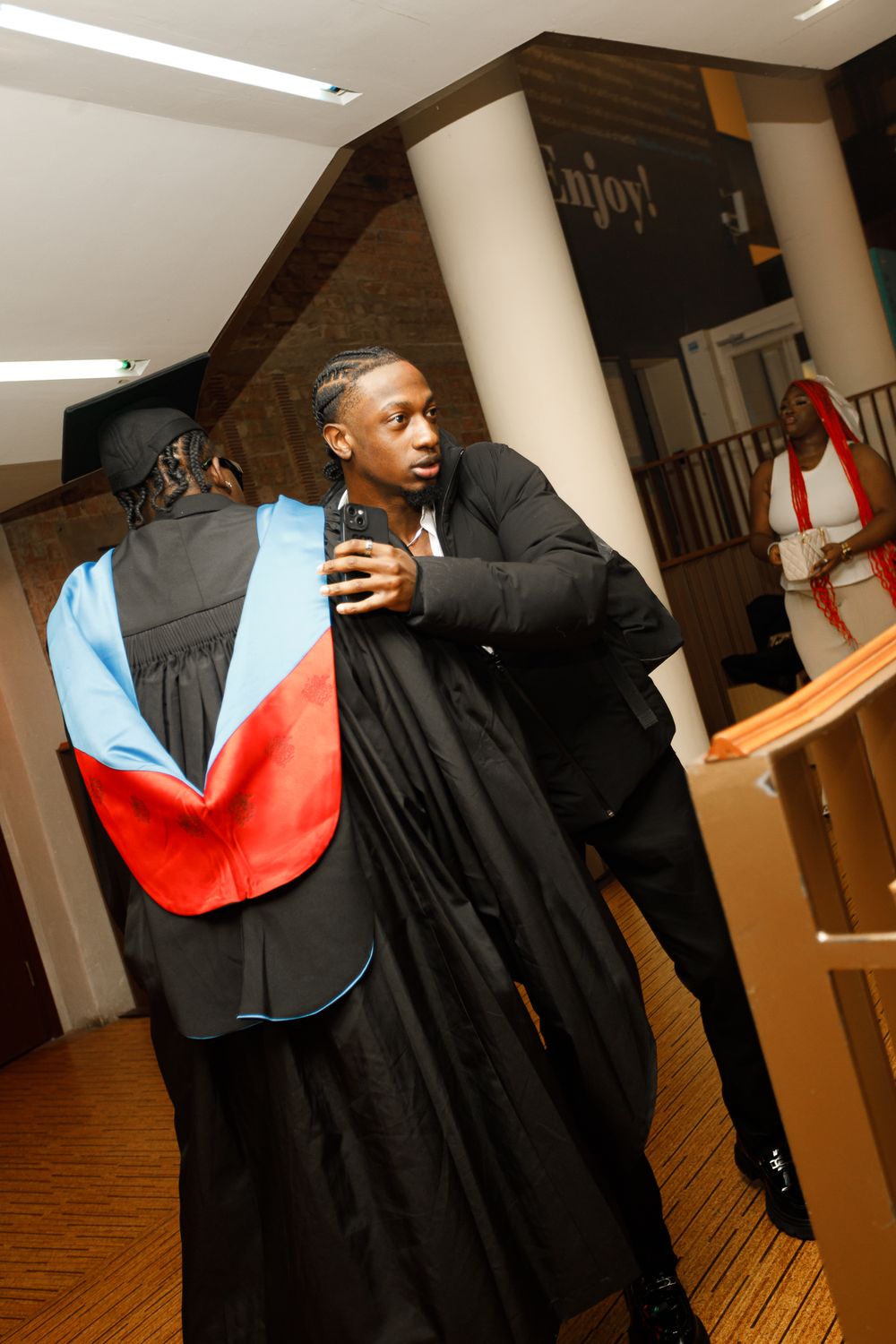 A sequence of dance moves showing a person in black clothing spinning with a red and blue fabric flowing behind them.