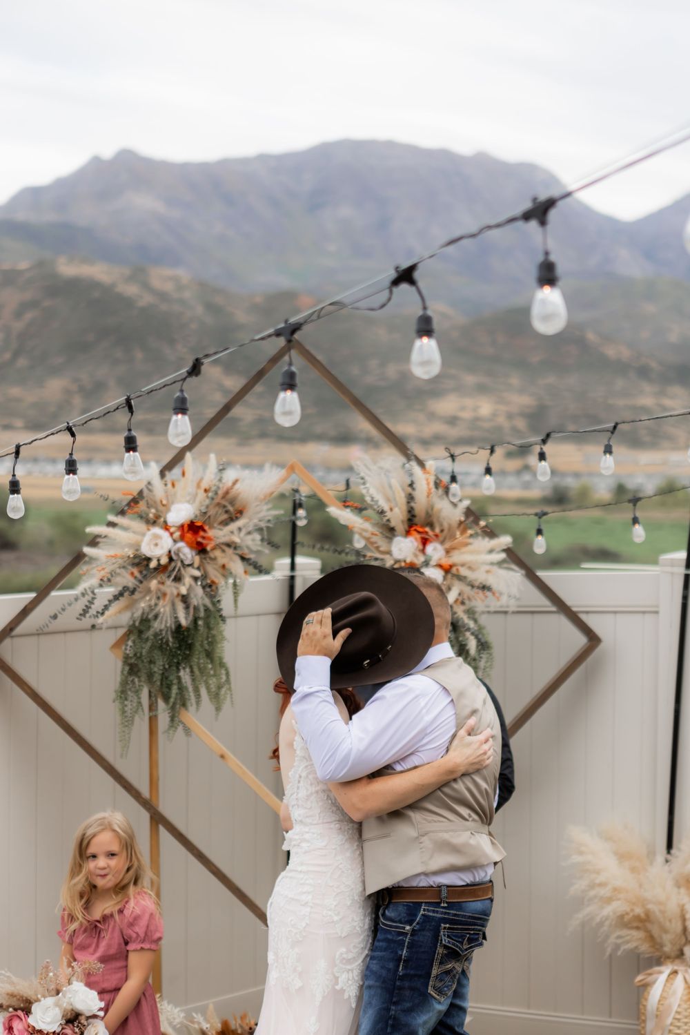 Bride and groom embracing during a backyard wedding ceremony in Utah
