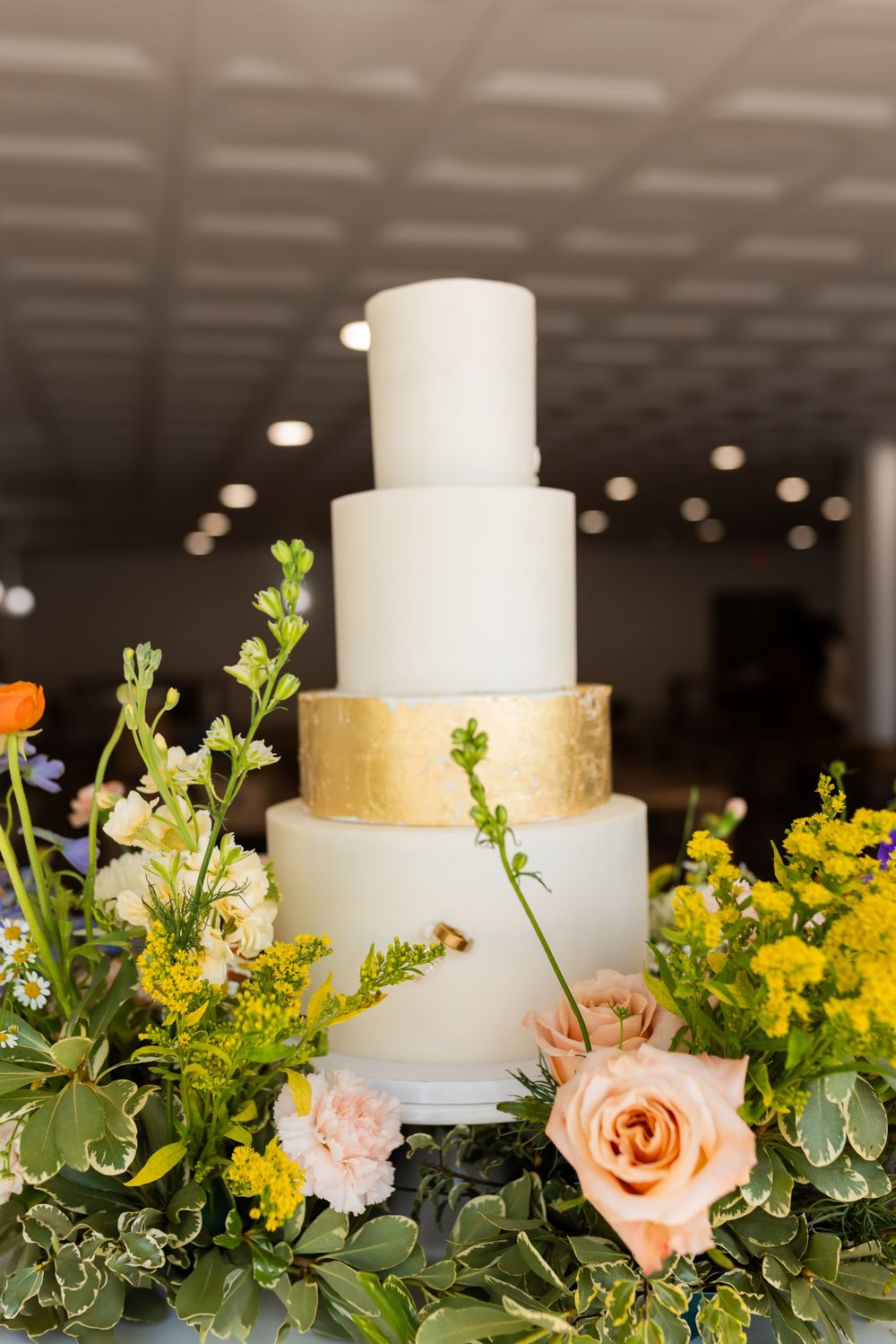 Minimal modern wedding cake with floral details photographed at a Utah wedding