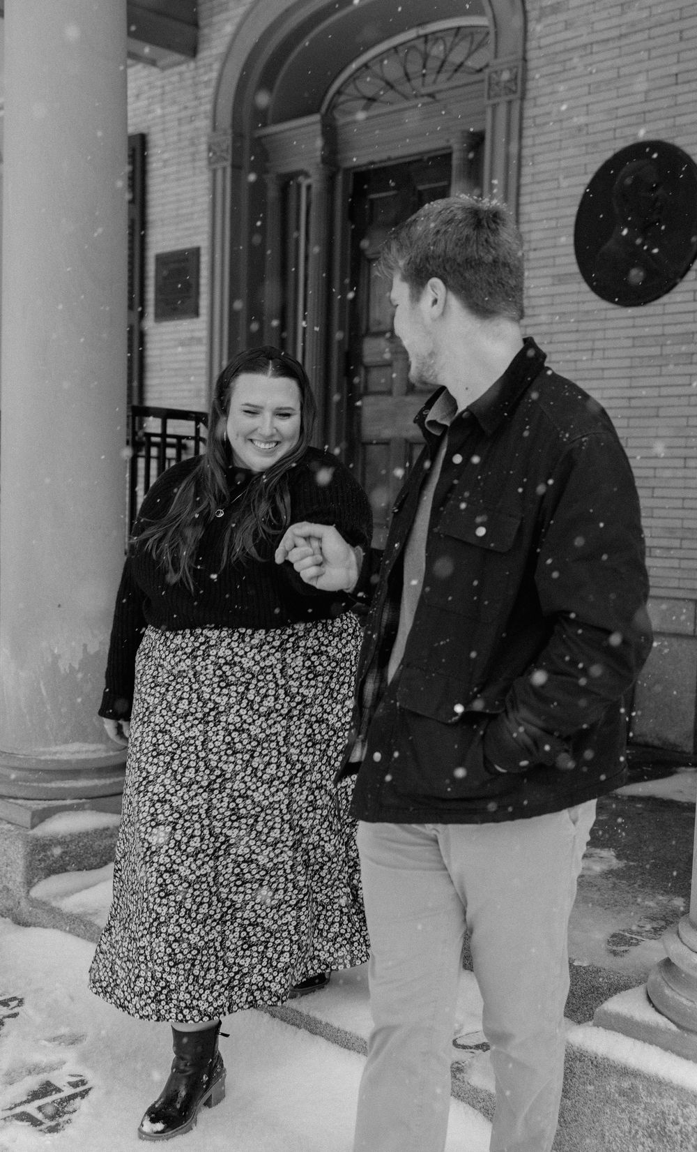 Engaged couple walking together at The Eastman Museum in Rochester during a winter engagement session
