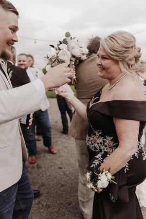 Wedding celebration candid moments showing guests and couple interacting outdoors.