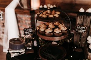 An array of desserts and cupcakes displayed on tiered stands at a wedding reception.