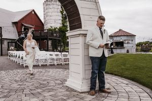 Wedding venue exterior showing rustic architecture and white ceremony chairs.