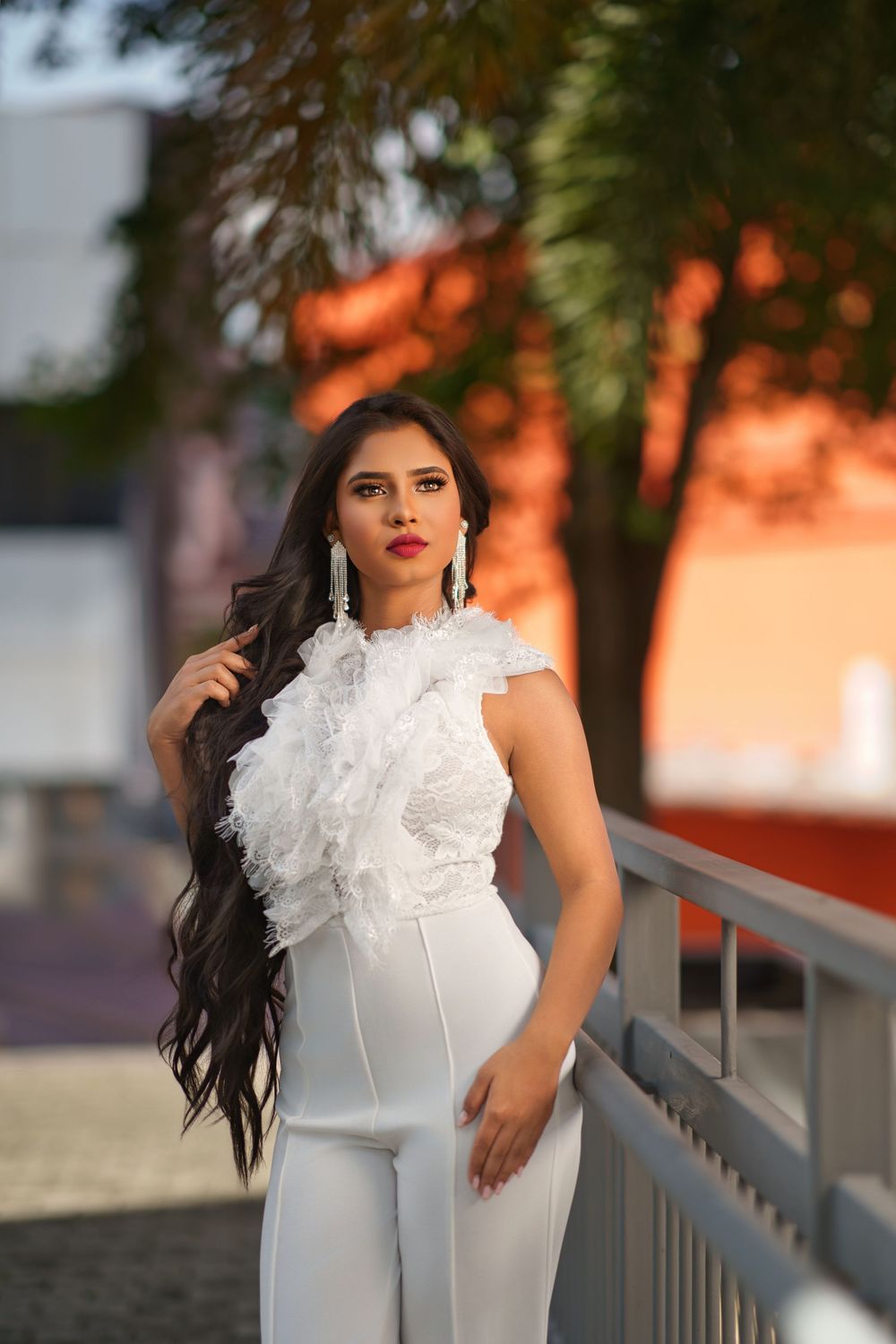 Fashion portrait series featuring a white ruffled high-neck dress against warm sunset lighting.
