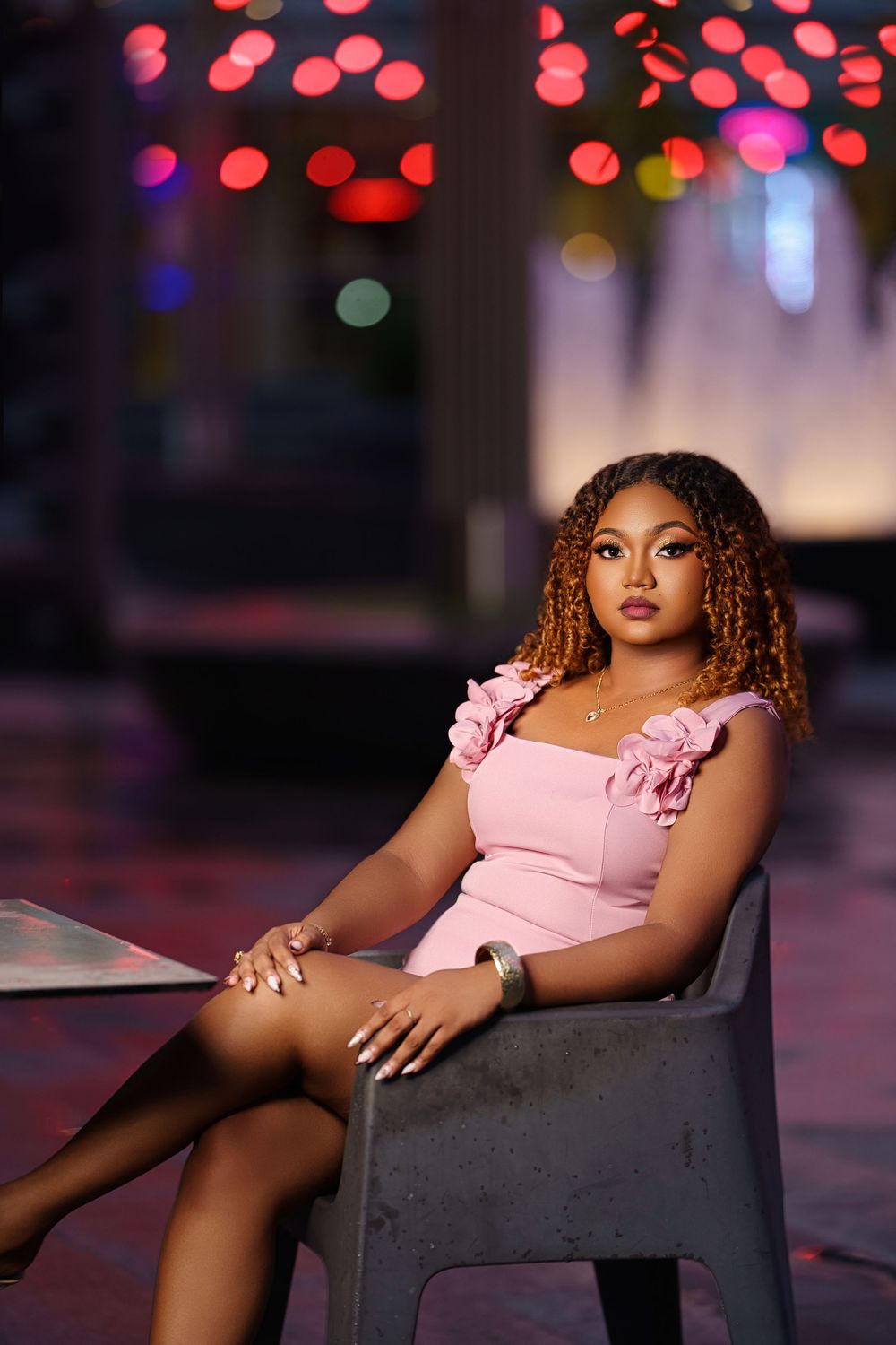 A glamour portrait session featuring pink dress and bokeh lights in the background creating a dreamy atmosphere.