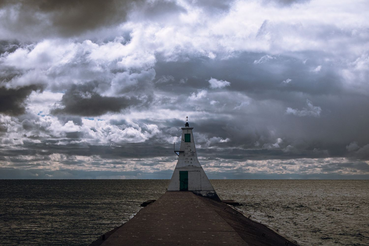 A dramatic series of lighthouse photos showing stormy skies and moody weather conditions over coastal waters.