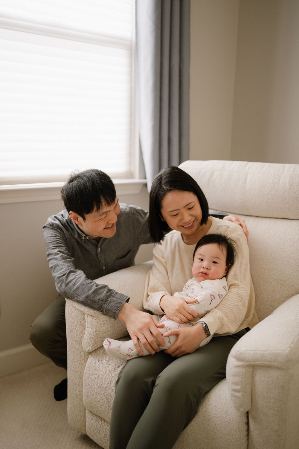 Sweet family moments shared on a white couch in a bright, modern living room.