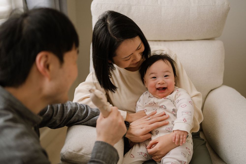 A family shares joyful moments together on a white couch.