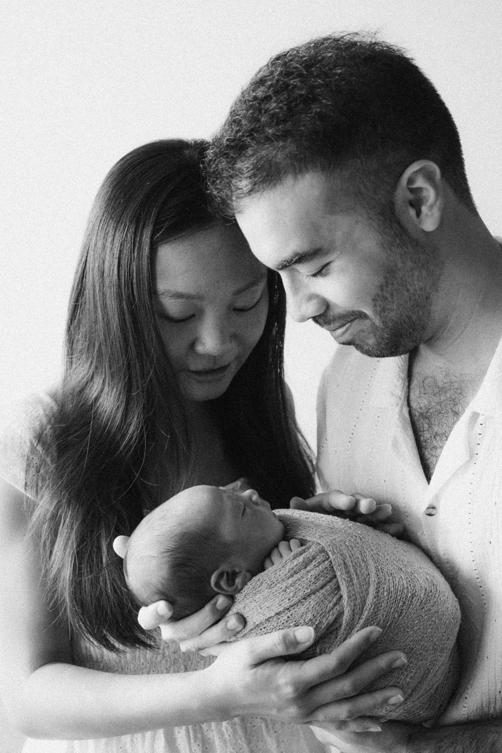 Intimate black and white series showing tender moments with newborn.