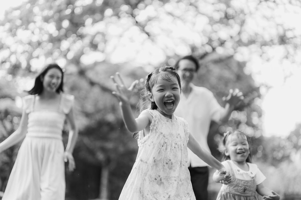 Black and white outdoor family photoshoot capturing joyful moments in nature.