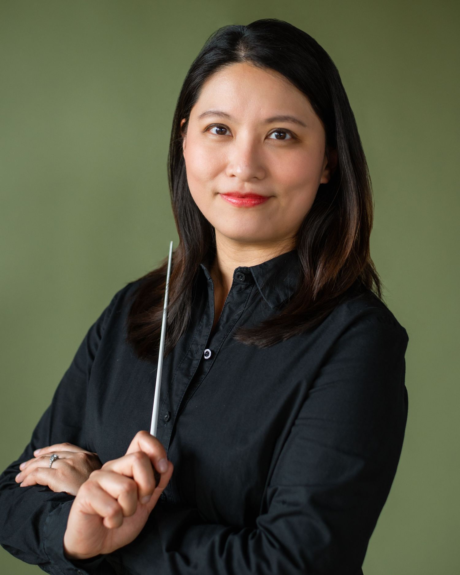 Professional headshots of someone in a black blazer posing with various expressions against a green background.