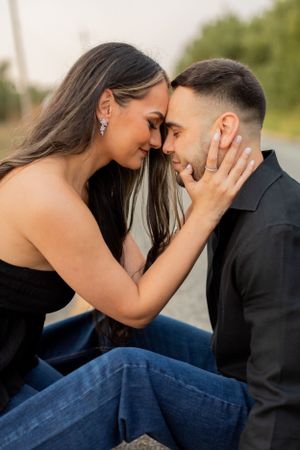 A tender romantic moment shared between a couple on a country road at sunset.