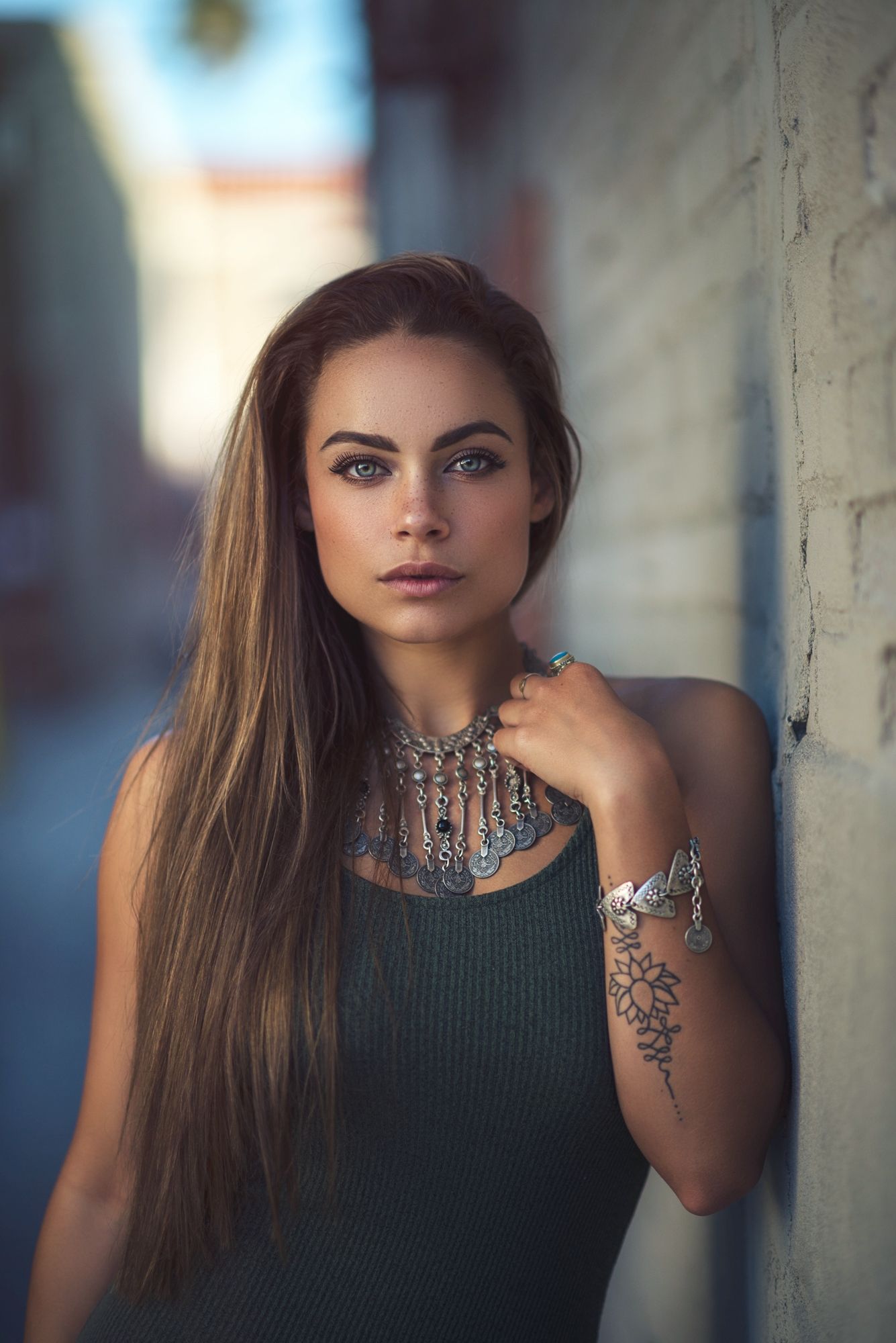 Dramatic portrait series featuring dark clothing and statement jewelry against urban backdrop.