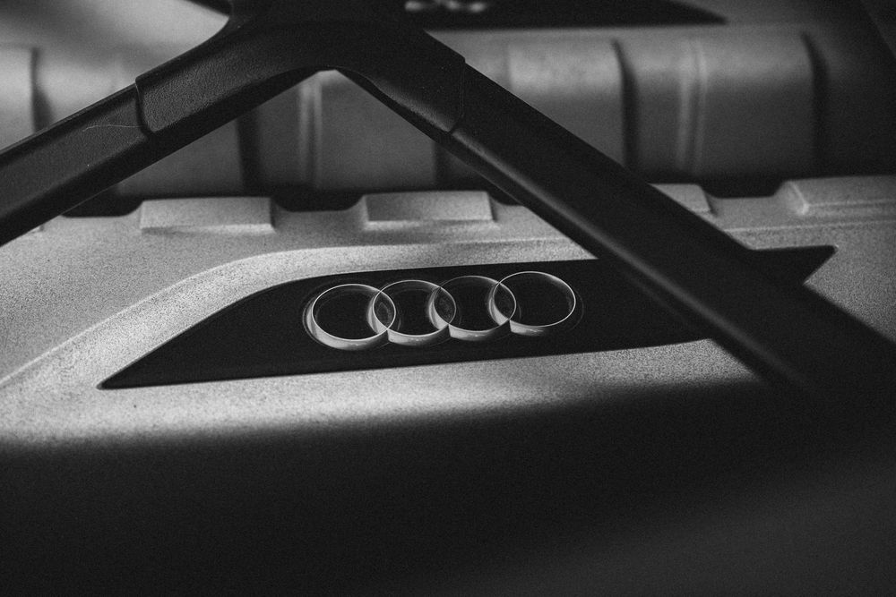 Close-up detail shots of a modern Audi vehicle exterior showing sleek design elements and chrome badging.