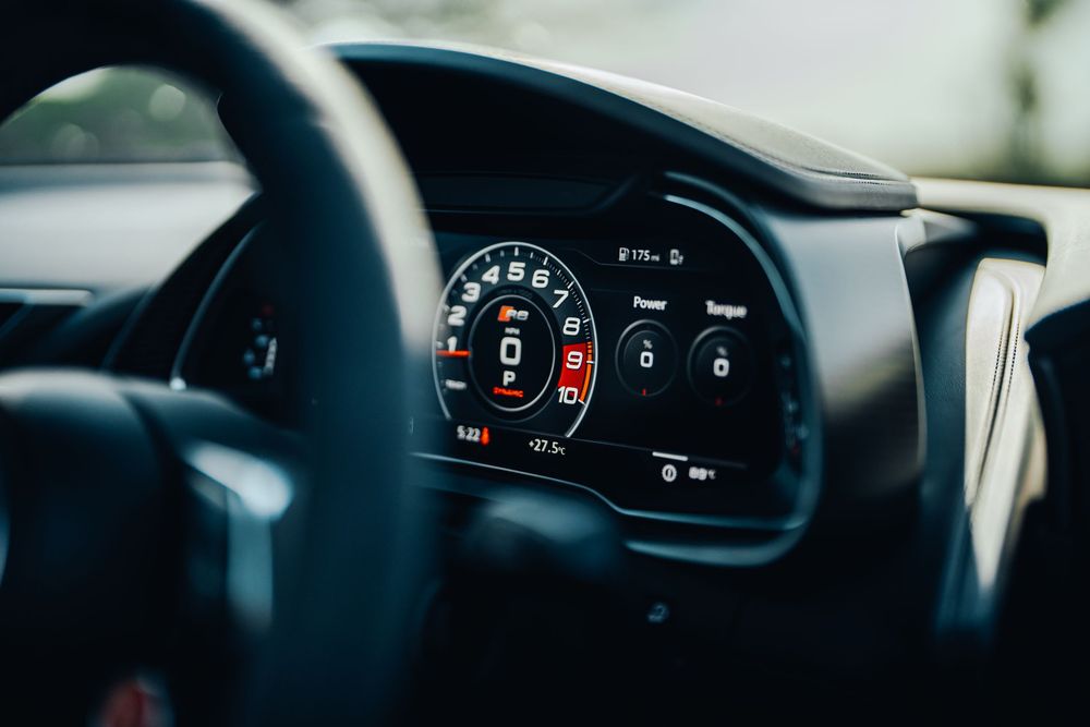 Modern car dashboard display showing digital gauges and instrument cluster illuminated at night.