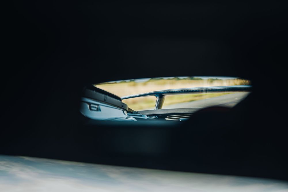Dark abstract automotive interior detail with blurred dashboard elements visible.