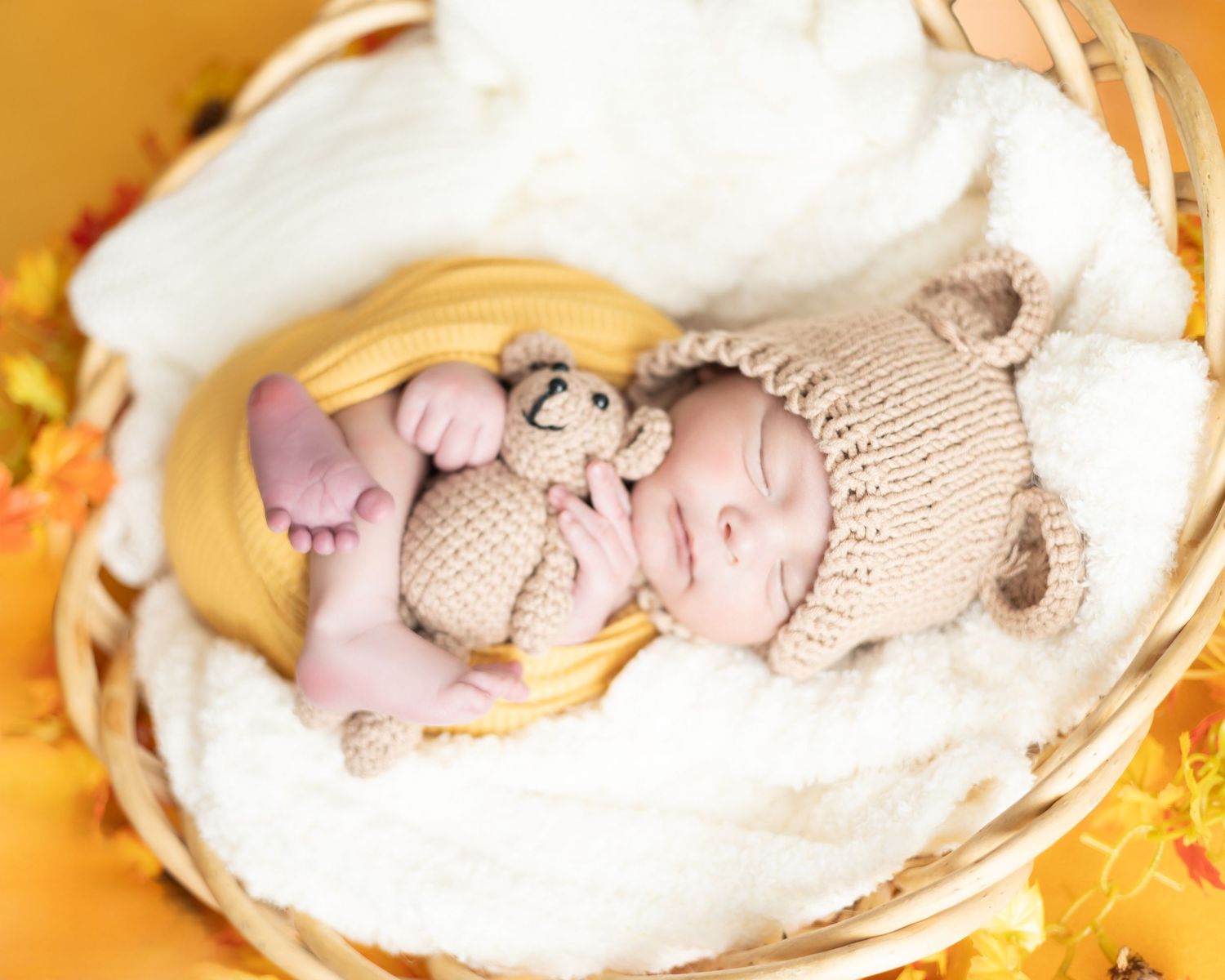A sleeping baby nestled in a cozy white blanket with soft lighting and warm golden tones in the background.