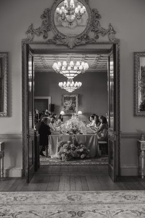 Elegant black and white interior shots of a luxurious ballroom with ornate chandeliers and decorative moldings.