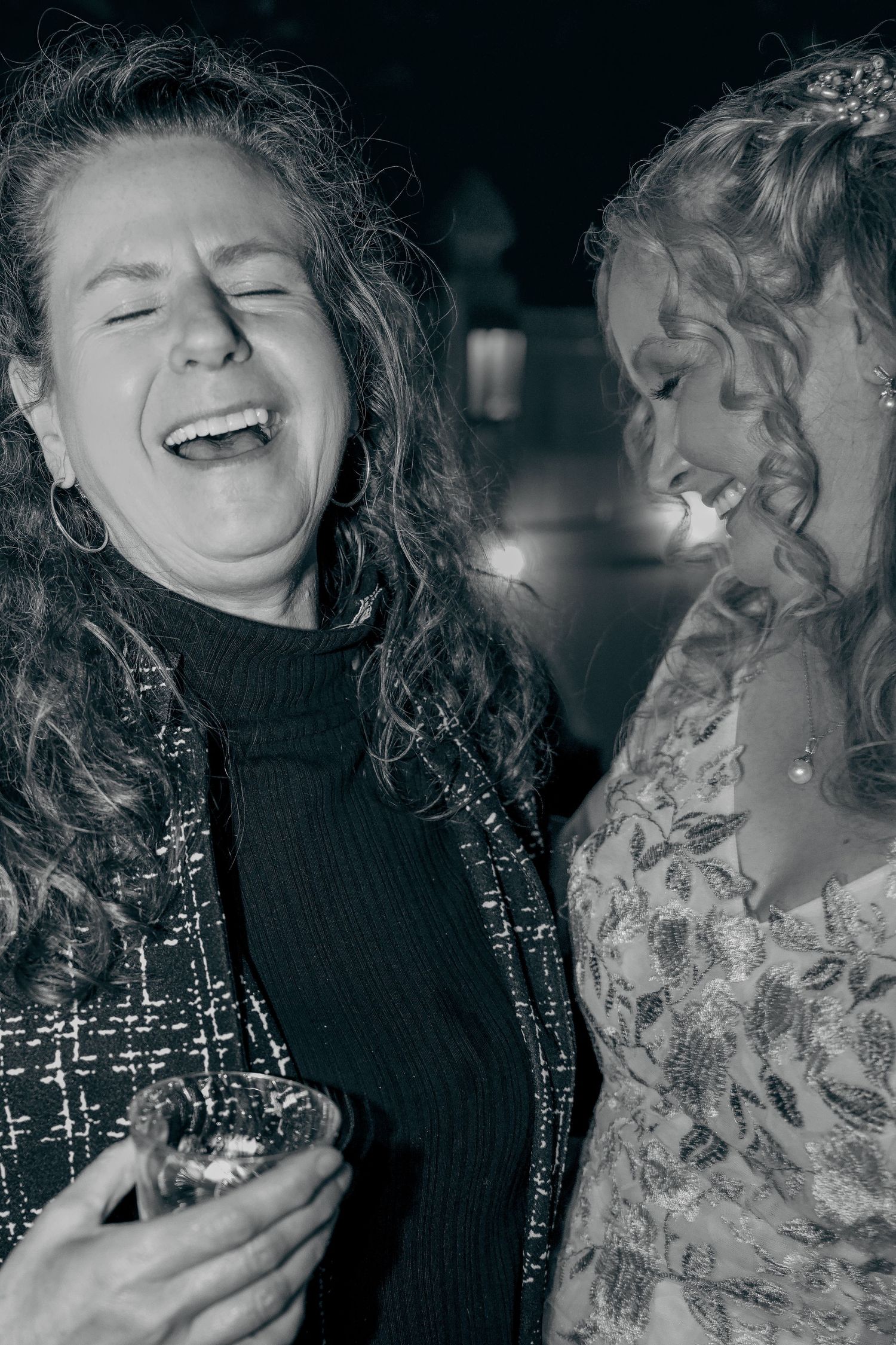 Black and white photo series showing two people laughing together in candid moments of joy.