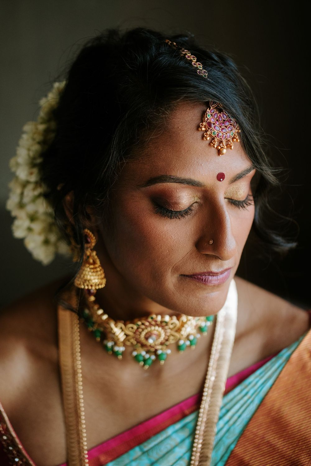 Close-up portrait shots of Indian bride wearing traditional jewelry and makeup in turquoise and pink saree.