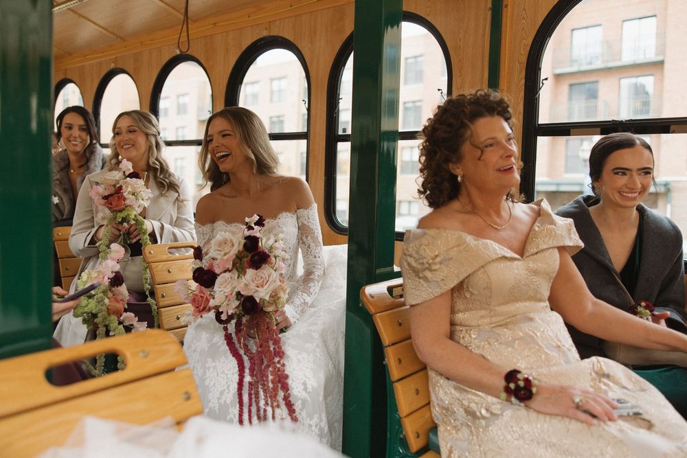 A bride in a white dress celebrates with guests during a reception at a rustic venue.