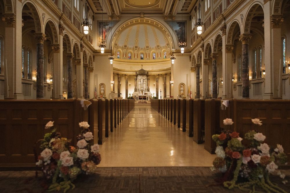 Ornate cathedral interior with golden arches and classical architecture illuminated by warm lighting.