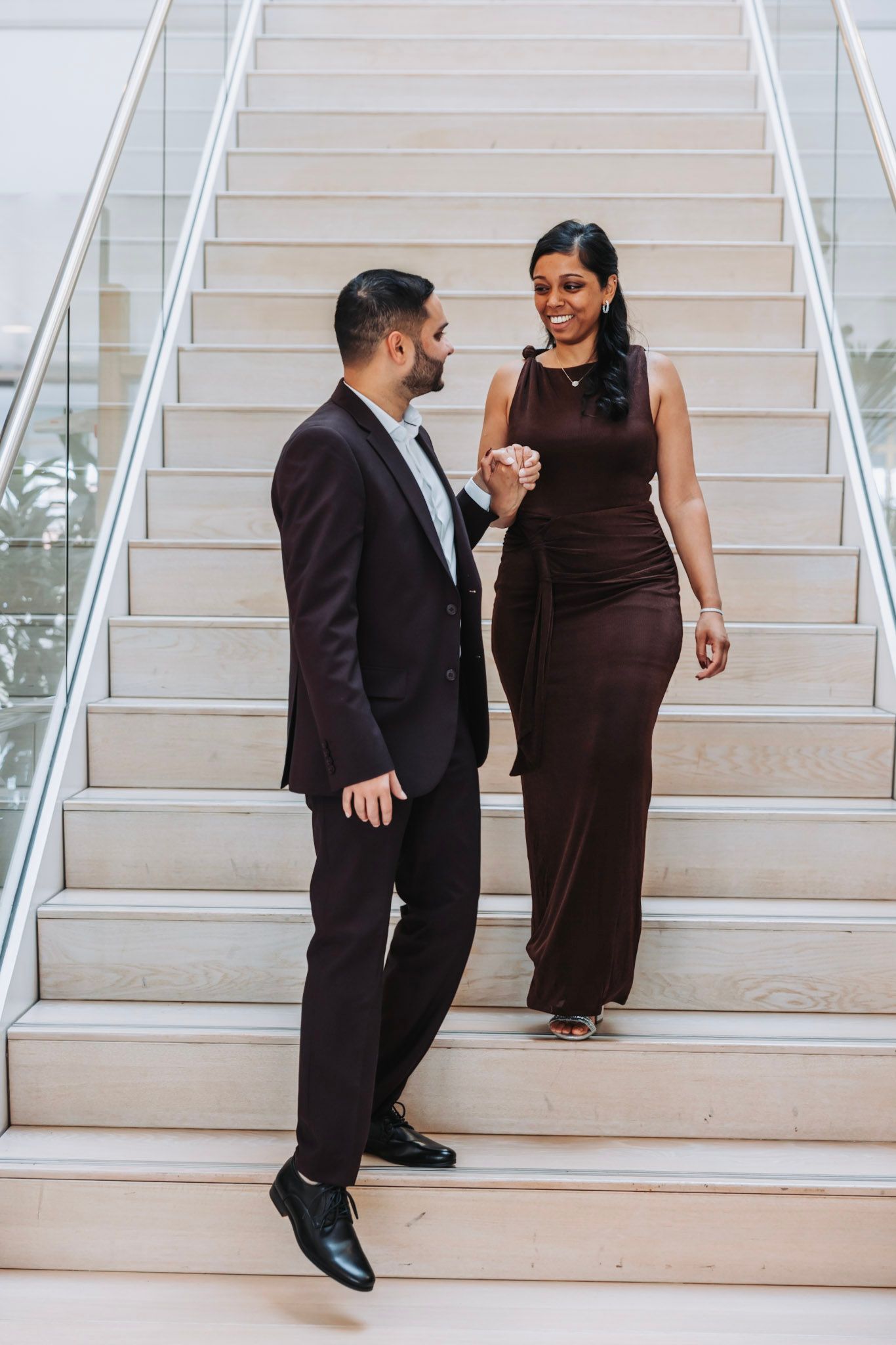 A couple poses on white stairs in formal attire in Gemeente Hoofddorp