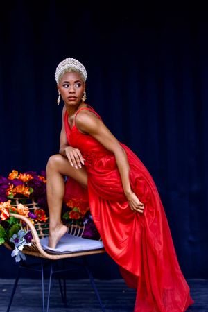 Elegant dance poses in flowing red dress against dark background with colorful floral accents.