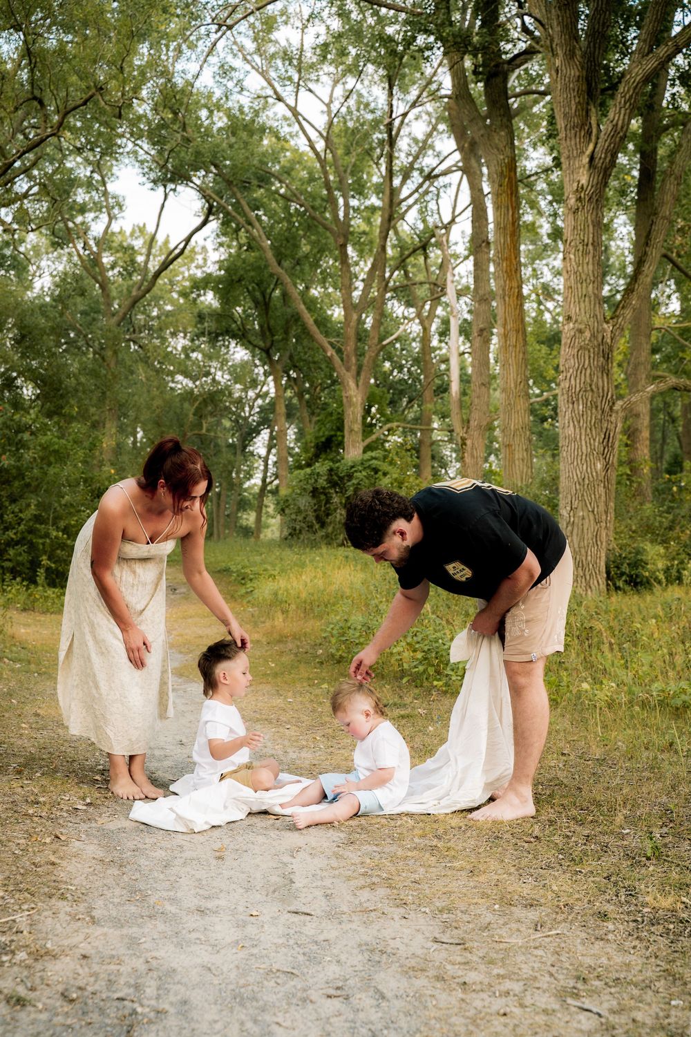 A sequence of playful moments on a wooded trail shows a tender interaction between family members on a sunny day.