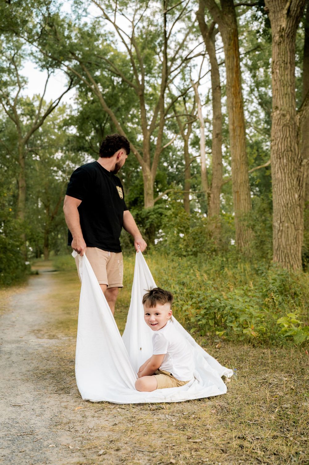 A playful sequence of photos on a wooded path shows a white blanket being laid out for a joyful moment.