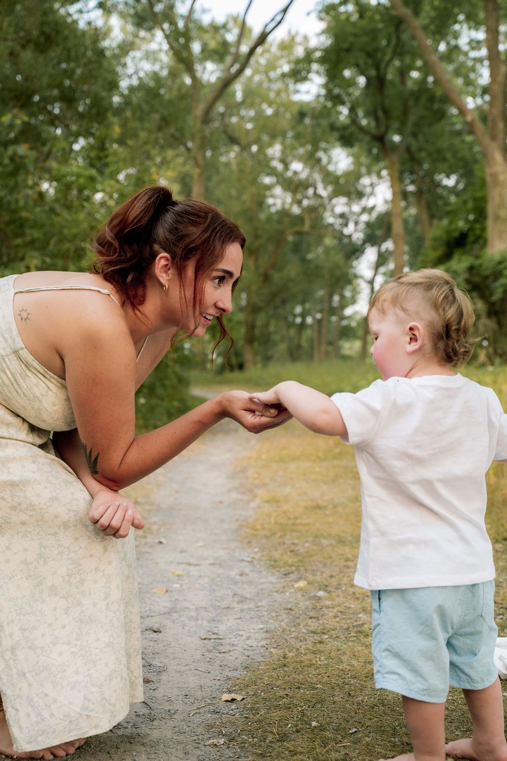 A sweet sequence of playful interaction between a parent and child on a nature trail.