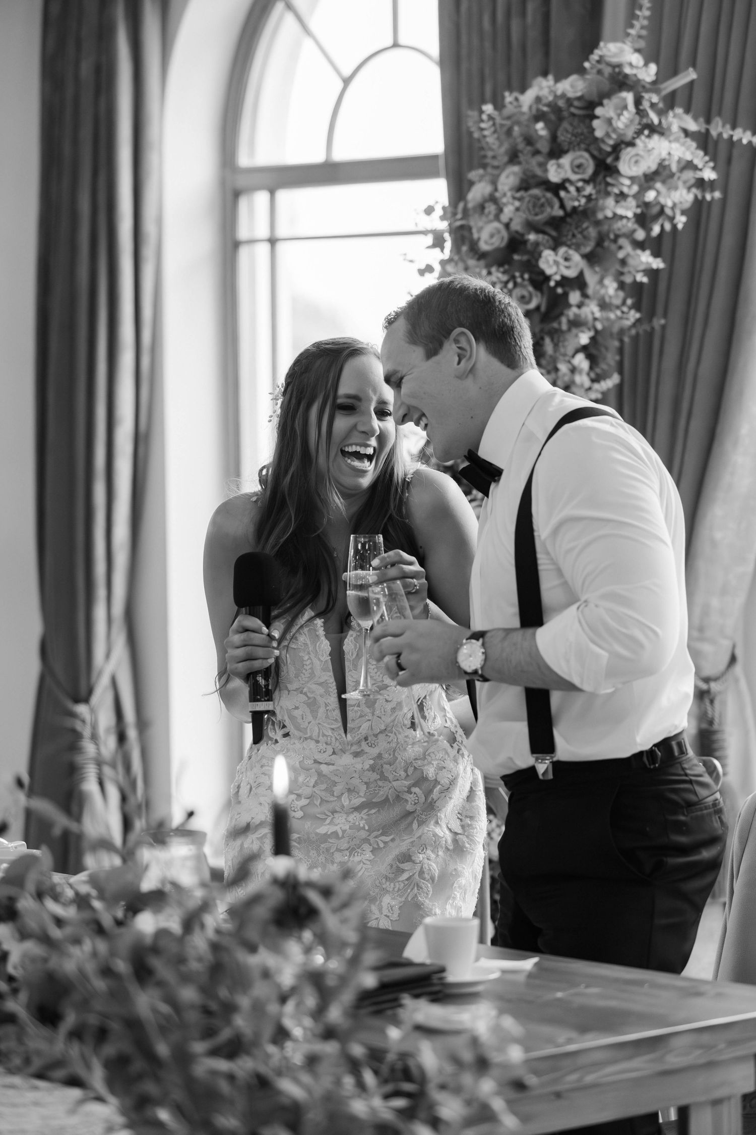Candid black and white wedding photos show joyful moments between couple during reception toasts and celebrations.